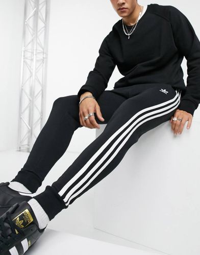 Adicolor - Joggers skinny con tre strisce, colore nero - adidas Originals - Modalova